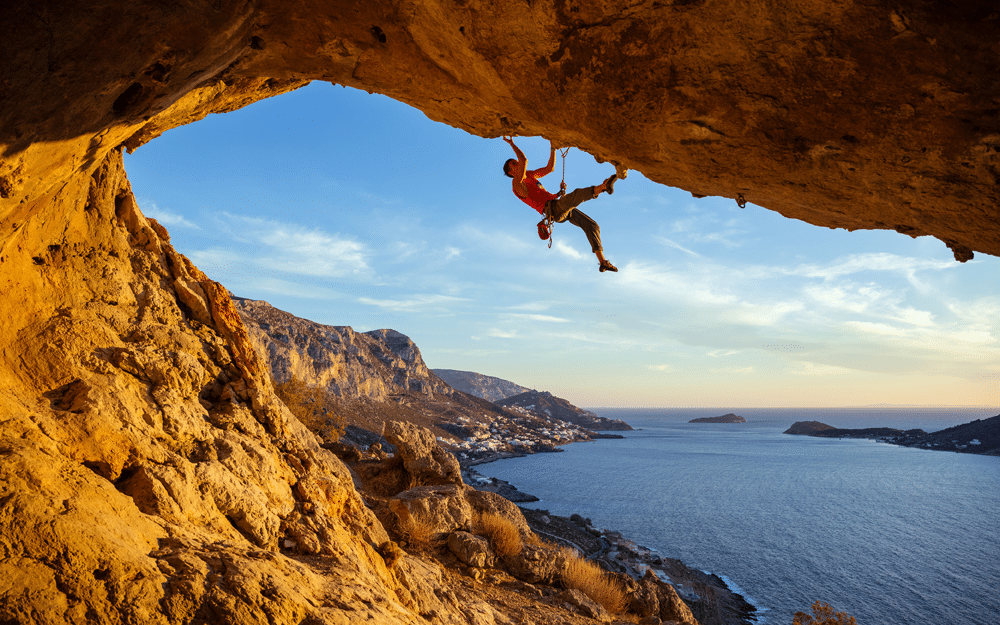 Rock climber on crag above the sea.  Rock climbing presents wilderness safety and outdoor risk management concerns, but real risks are low if climbing is managed well.